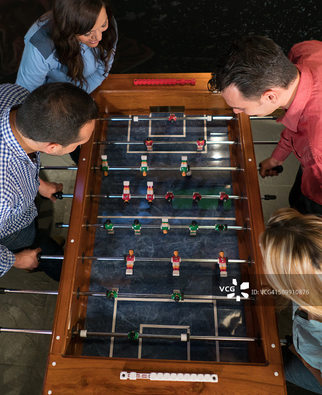 一群朋友在酒吧玩桌上足球图片素材