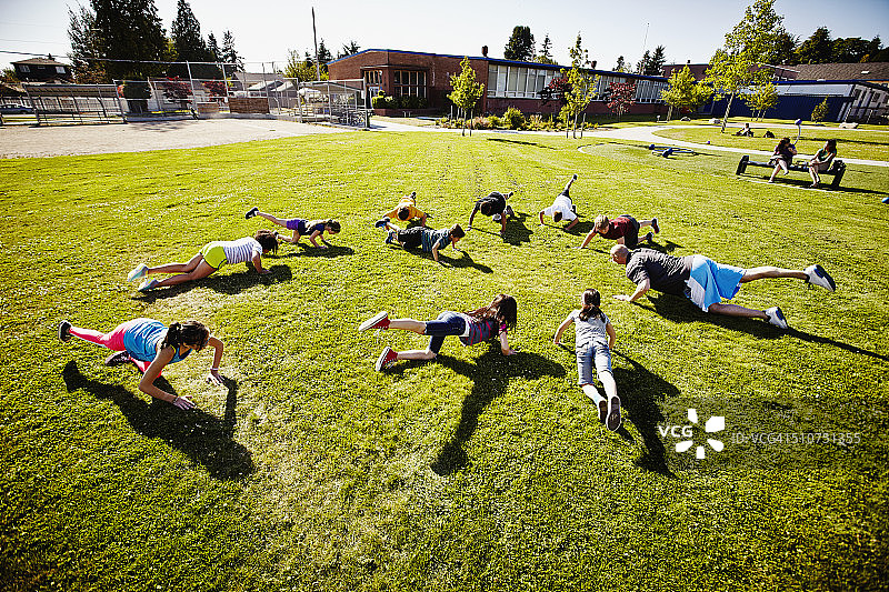 一群孩子在体育课上做抬腿运动图片素材