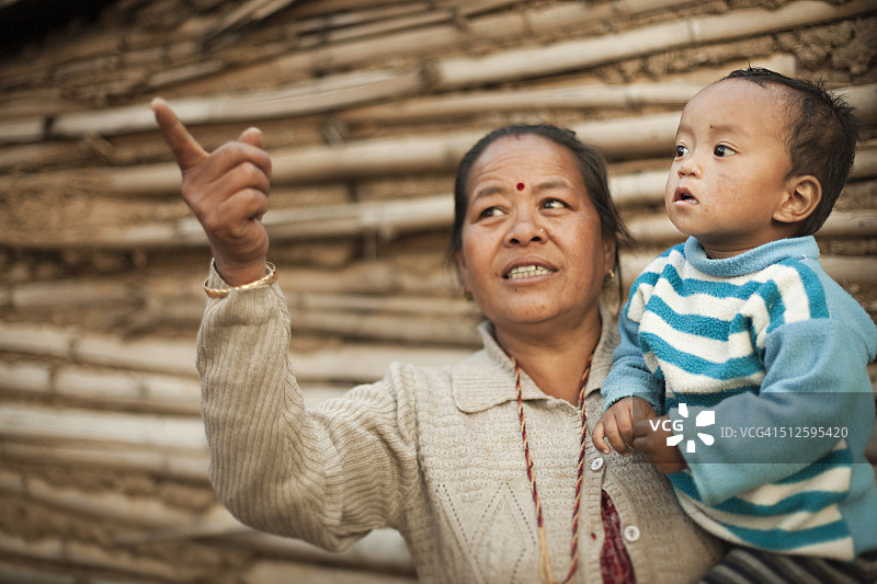 亚洲农村妇女向她的孙子展示一些东西。图片素材
