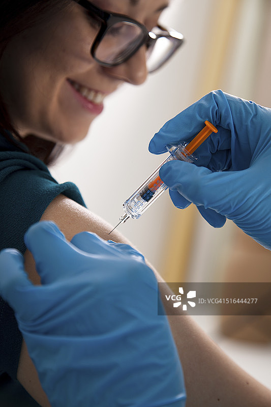 医生:在药房诊所给病人注射流感疫苗的护士。图片素材
