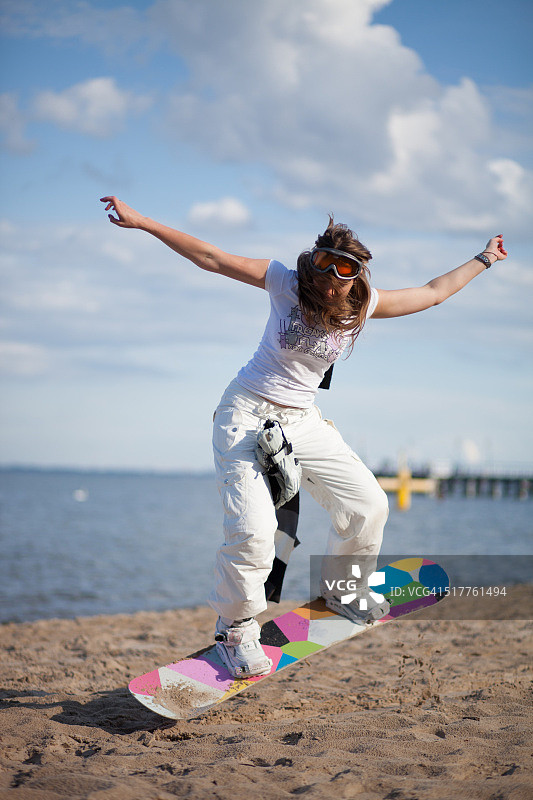 海滩上玩滑雪板的女孩图片素材