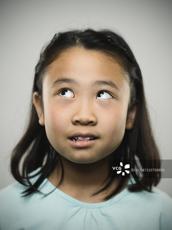 一个年轻的日本女孩抬头看的肖像。图片素材