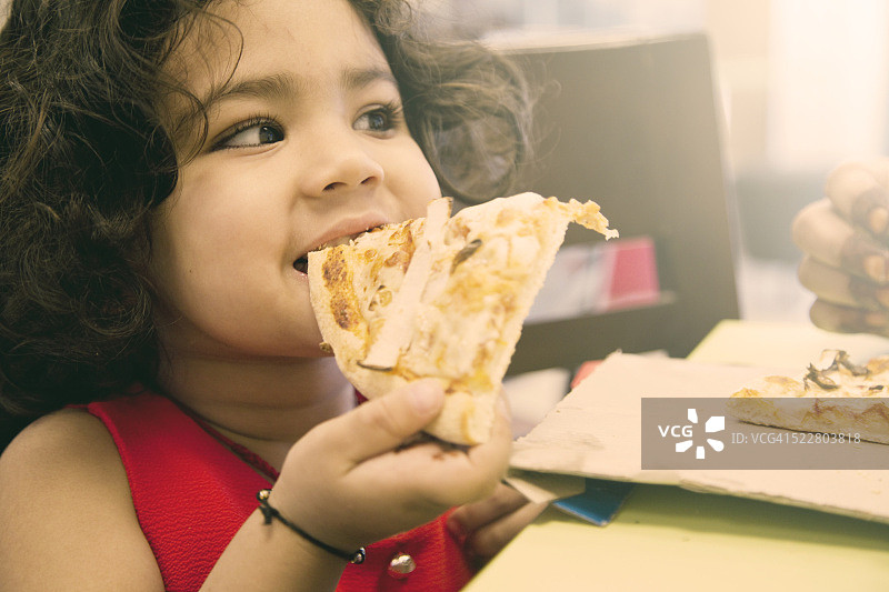 小女孩吃披萨图片素材