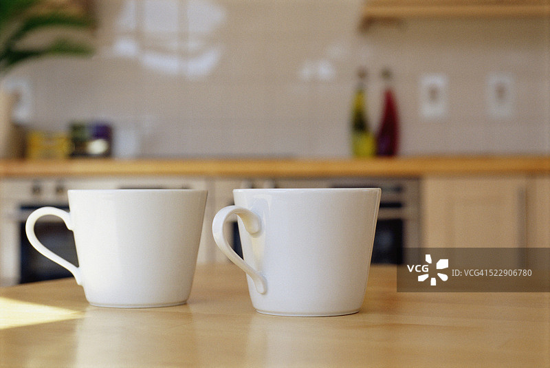 两个咖啡杯坐在厨房柜台上的细节视图图片素材
