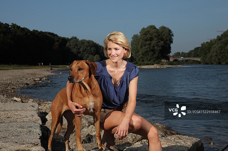 德国慕尼黑伊萨尔河的女人和狗图片素材
