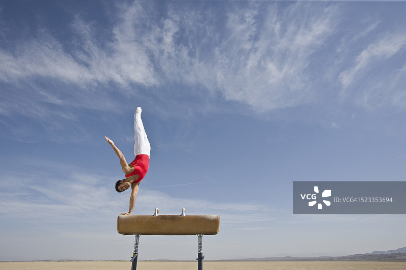 体操运动员在沙漠鞍马上表演图片素材