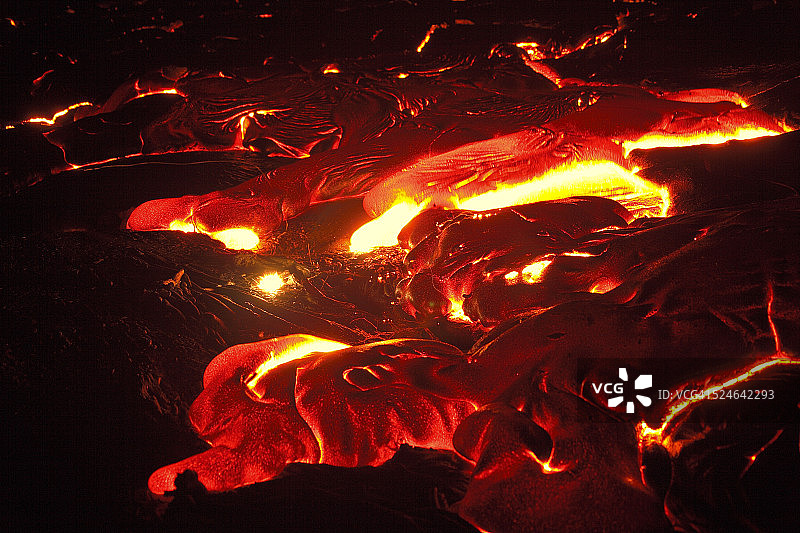 晚上炽热的熔岩流的细节。图片素材