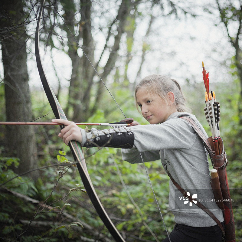 女孩(10-12)用蟒蛇和箭射击图片素材