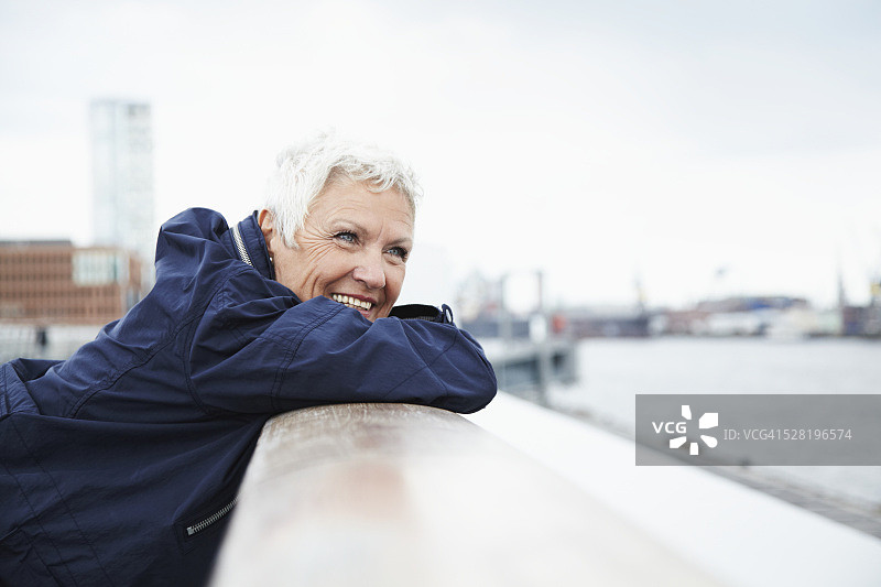 德国汉堡，靠在码头栏杆上的老妇人肖像图片素材
