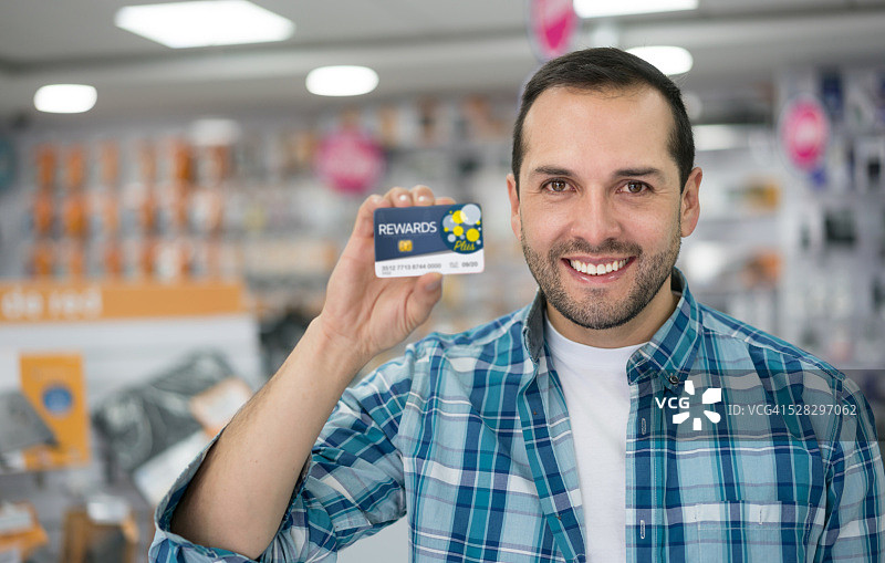 一个拿着奖励卡在科技店里的男人图片素材