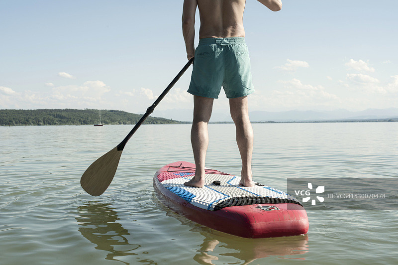 后视图的一个成熟的男子桨板在湖，巴伐利亚，德国图片素材