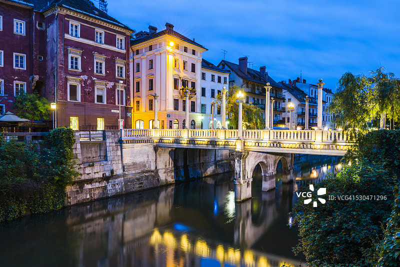 欧洲，斯洛文尼亚，卢布尔雅那，夜晚的卢布尔雅那河上的桥图片素材