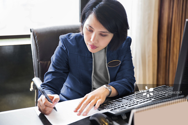 亚洲女性酒店礼宾在她的办公桌工作图片素材