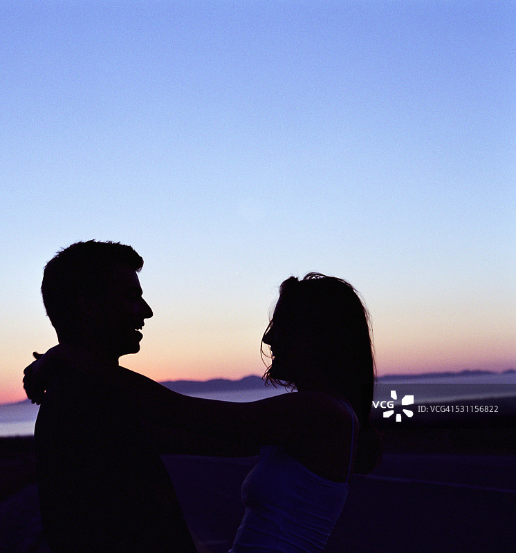 情侣在日落时分拥抱图片素材
