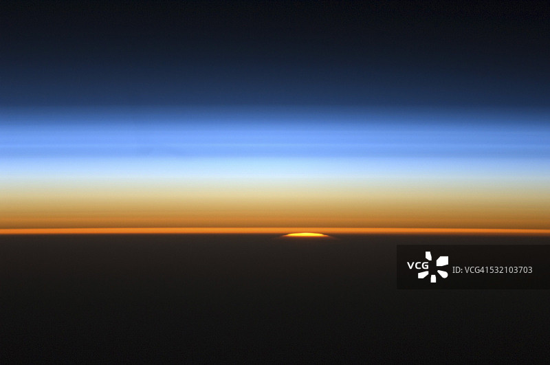 太阳从地球边缘探出头来的景象。图片素材