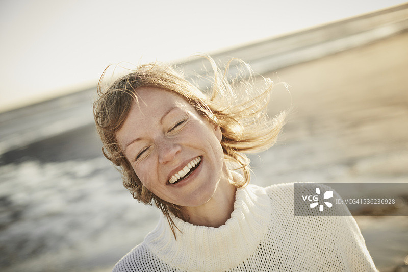 海滩上闭着眼睛的快乐女人图片素材