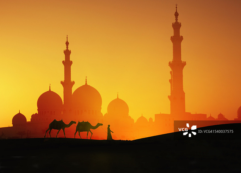 日落时分骑着骆驼和清真寺的阿拉伯人图片素材