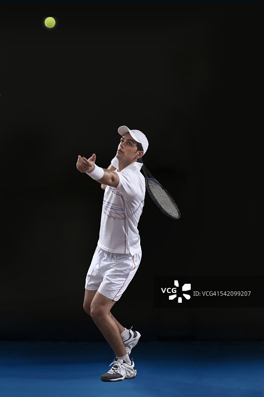 年轻男子网球运动员在球场上准备发球的全身姿势图片素材