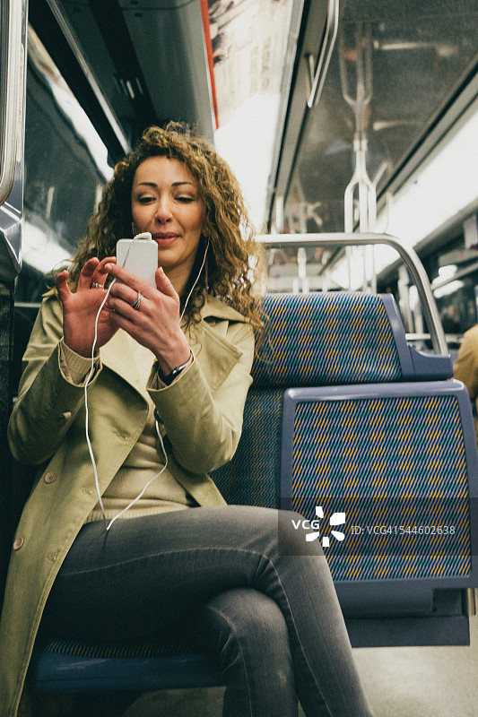 快乐的女人在地铁上打电话图片素材