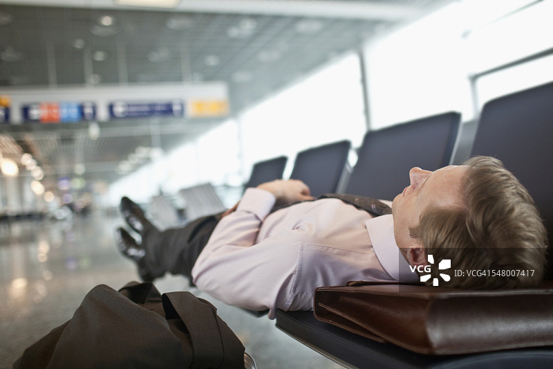 在机场候机楼睡觉的商人图片素材
