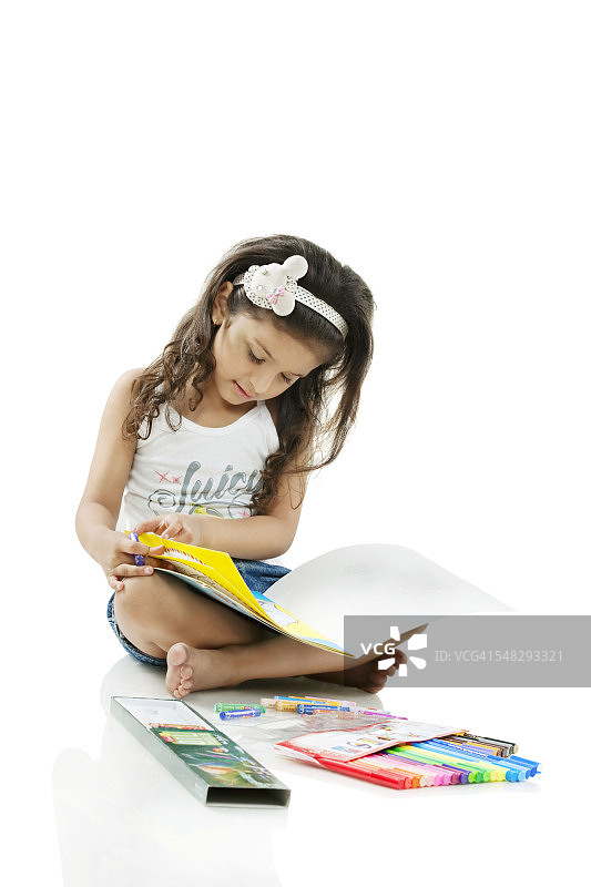 女孩在看一本涂色书图片素材