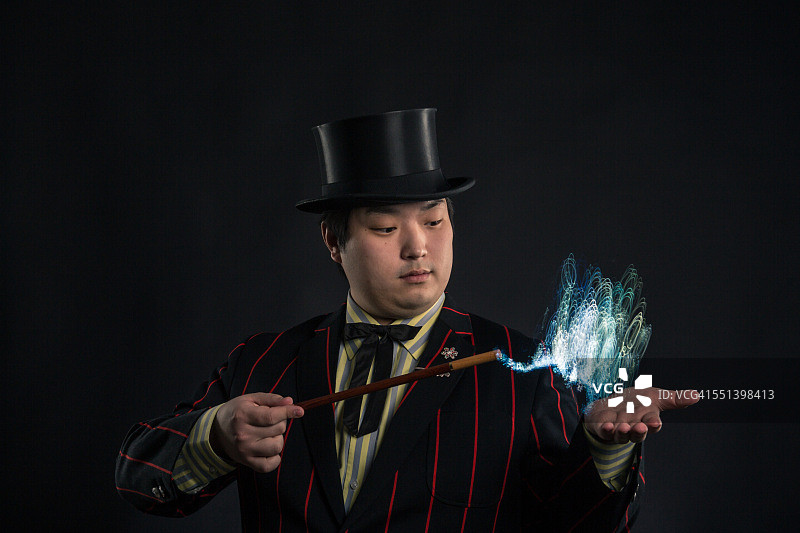 一个魔术师用他的魔杖发出光图片素材