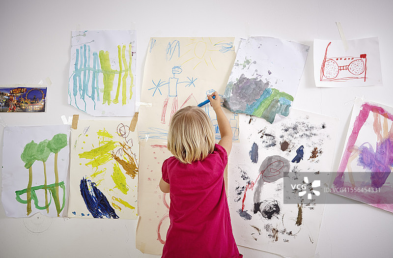 小女孩画在儿童房的墙上，后视图图片素材