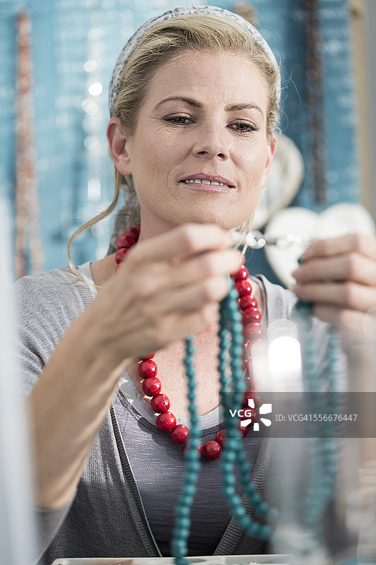 一个女人正在检查一条珠子项链图片素材