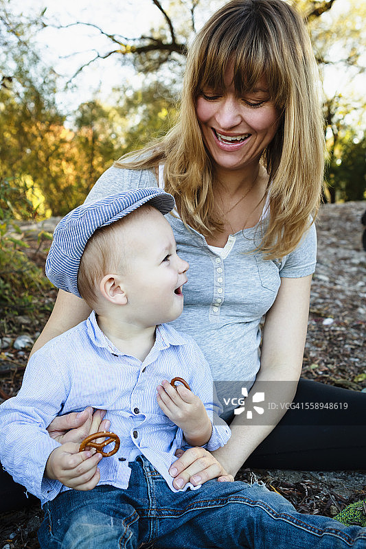 母亲和儿子坐在一起，在户外，在乡村环境中图片素材