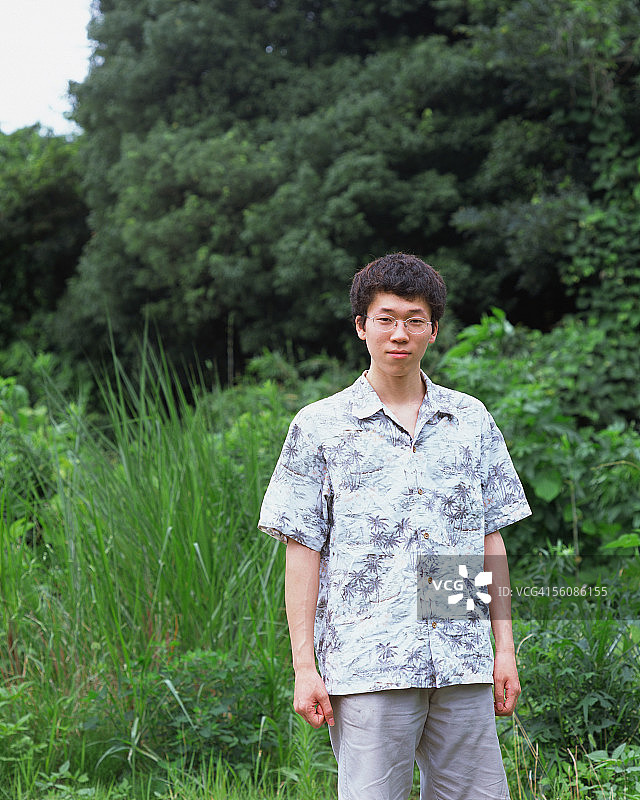 一个年轻人站在田野里图片素材