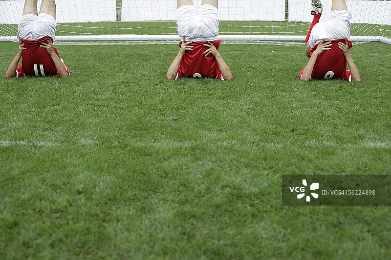 足球运动员在球门前做伸展运动图片素材