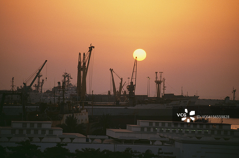 日落时，几艘船停泊在港口。图片素材