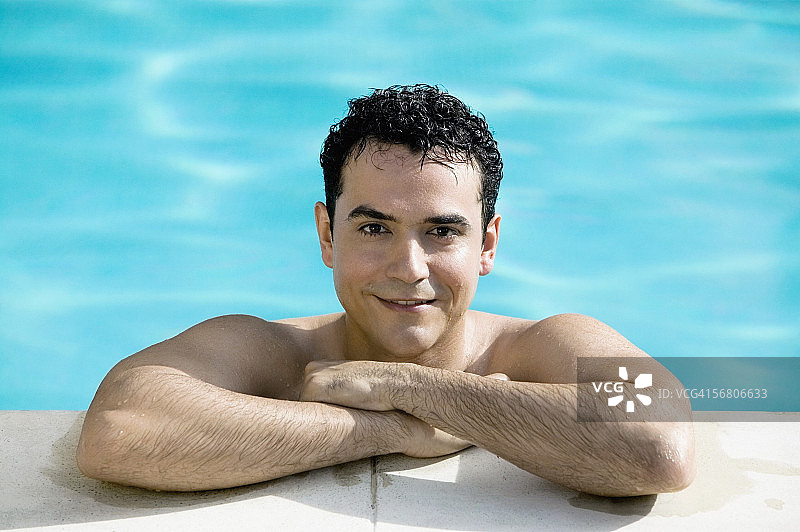 一个年轻男子在游泳池微笑的肖像图片素材