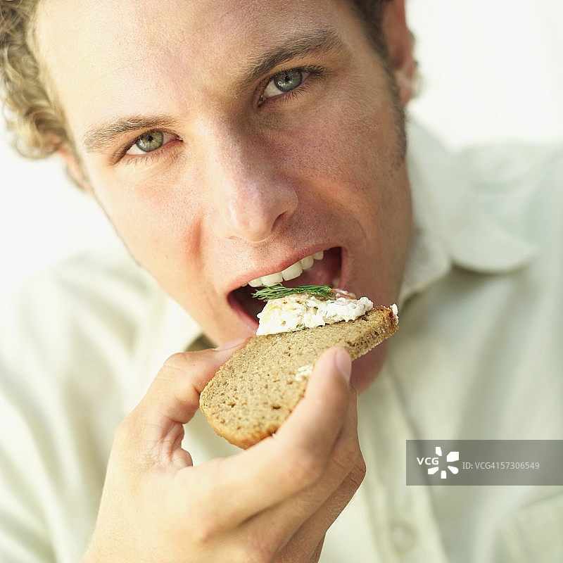 一个人吃一片面包和奶酪的特写镜头图片素材