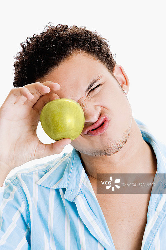 一个拿着苹果的年轻人的肖像图片素材