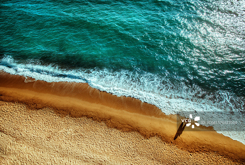 一个冲浪者女孩在海滩上休息的鸟瞰图图片素材