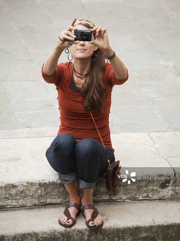 意大利，威尼斯，一个女人在台阶上用数码相机拍照图片素材