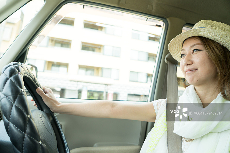 开朗的日本女人开着车穿着图片素材