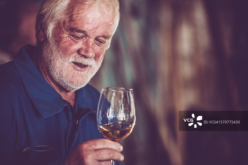 胡子老人喝着白葡萄酒图片素材