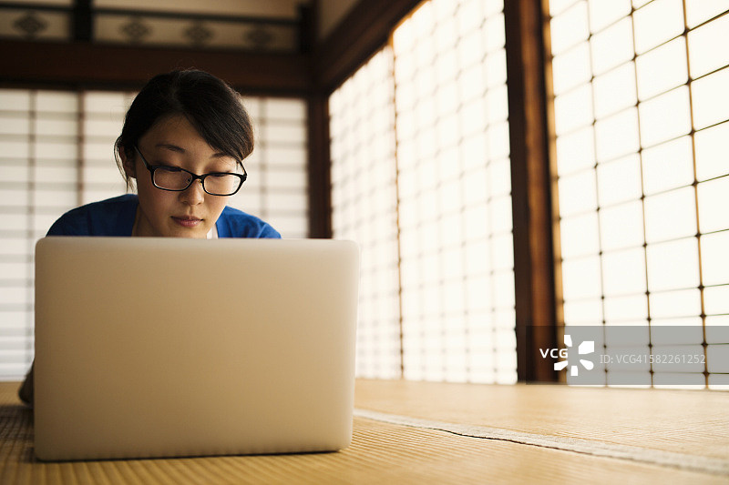 一个在日本寺庙里使用笔记本电脑的女人图片素材