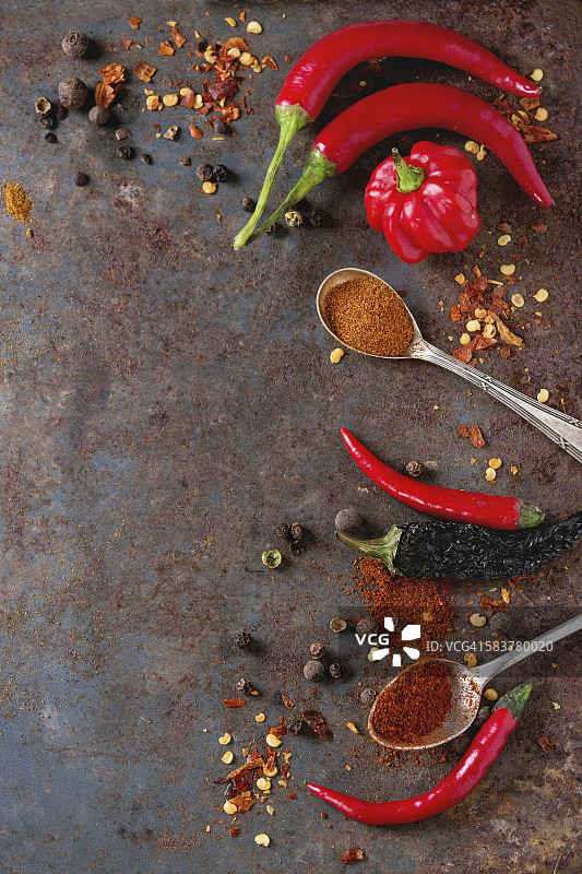 辛辣的背景与各种不同的辣椒和多香辣椒在旧生锈的铁背景。前视图。与复制空间图片素材