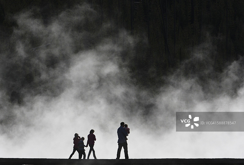 一个剪影家庭走过火山蒸汽图片素材