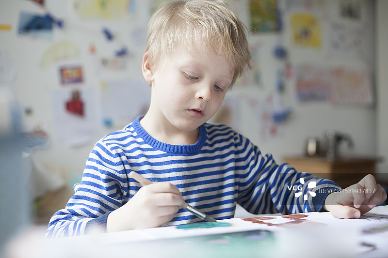 金发小男孩用水彩画的肖像图片素材