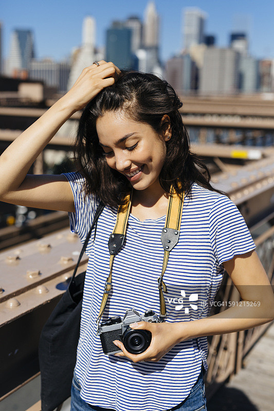 美国，纽约，微笑的年轻女子与相机的肖像图片素材