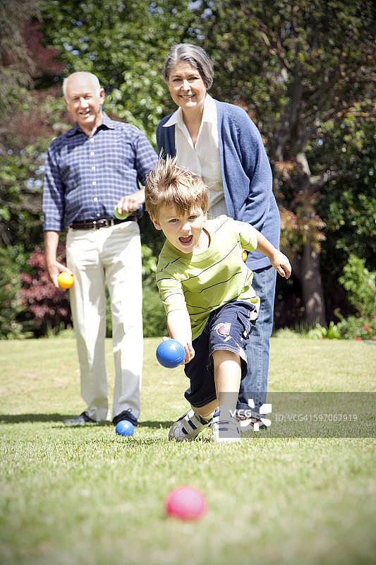 小男孩和爷爷奶奶玩地滚球图片素材