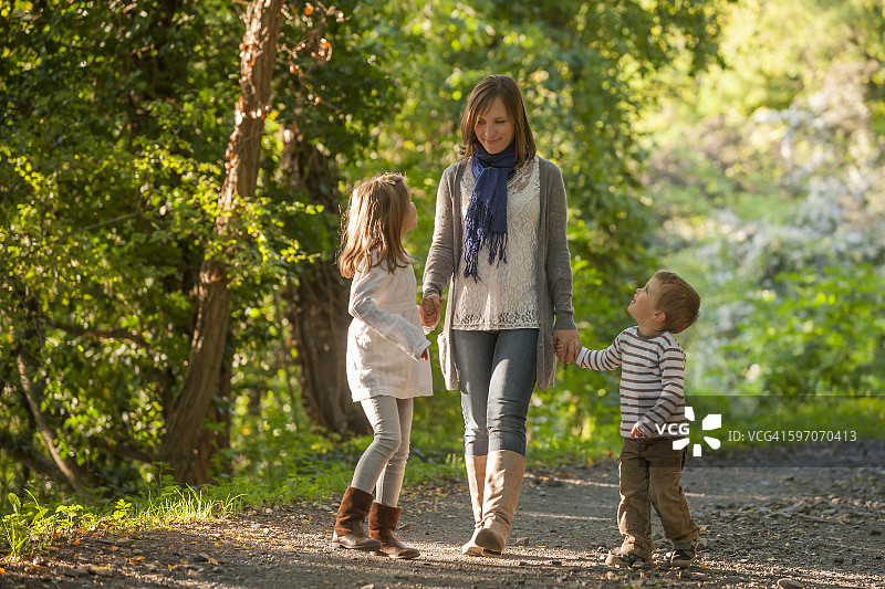 母亲和她的孩子们在森林小径上散步图片素材