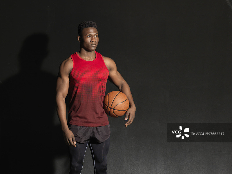 篮球运动员的肖像与球，黑色背景图片素材