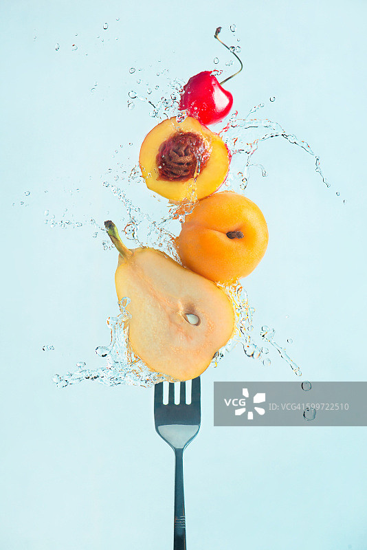 夏日小吃:用叉子夹新鲜水果图片素材