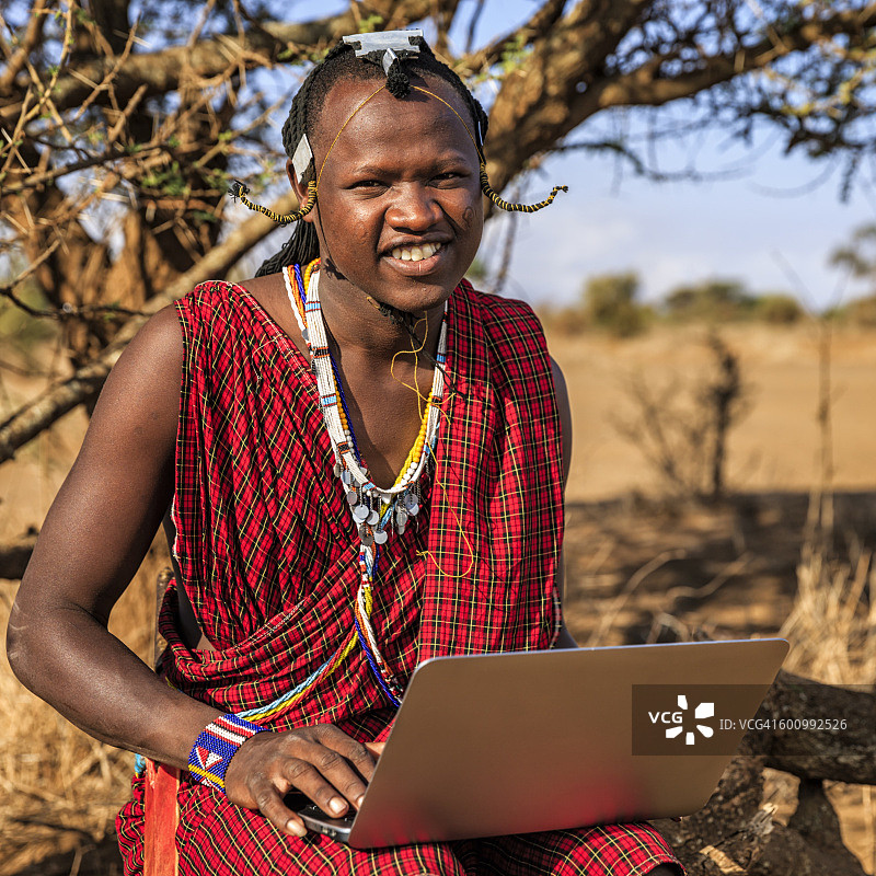 来自马赛部落的战士使用笔记本电脑，肯尼亚，非洲图片素材