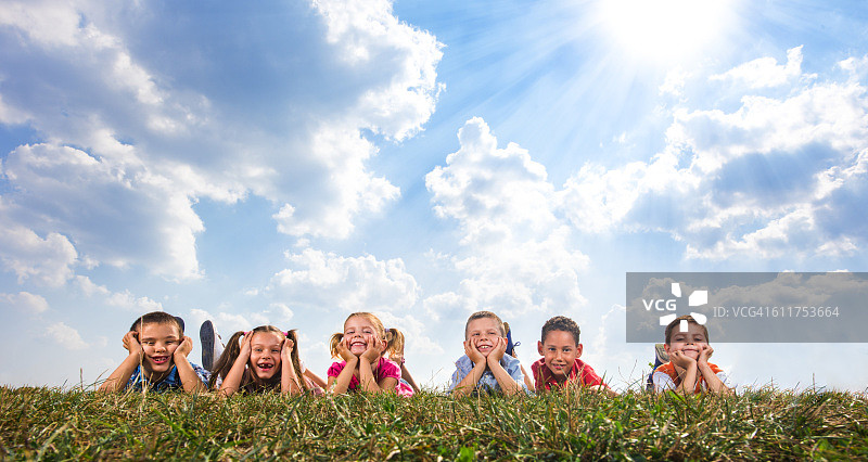 可爱的孩子们在草地上放松的全景。图片素材